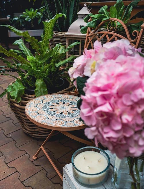 Romantický nábytek na zahradu – zahradní židle, rostliny na zahradu, vonná svíčka a zahradní lucerna